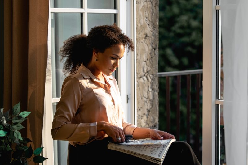 Girl sitting in doorway reading magazine