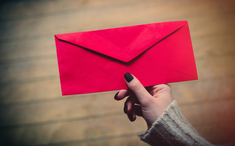 A hand holding a red envelope