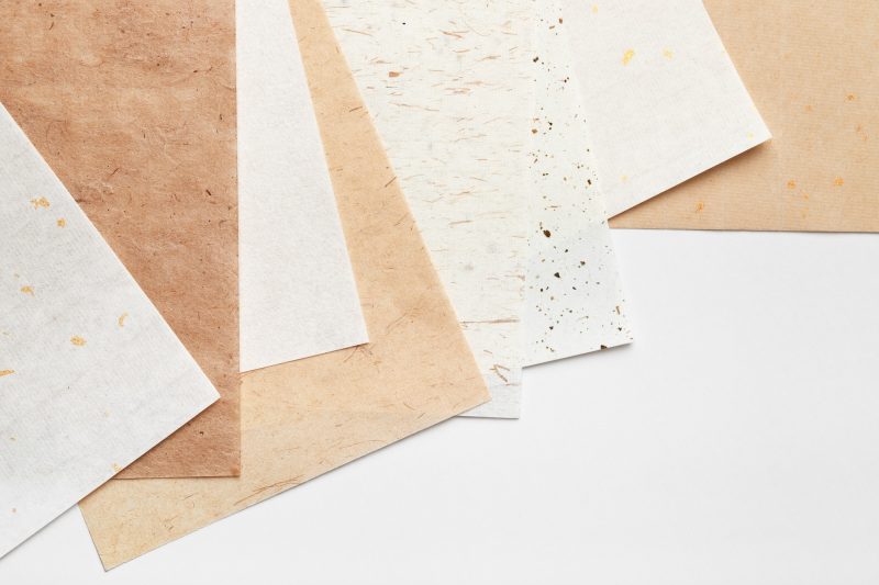 Stack of different types of paper on a white background.