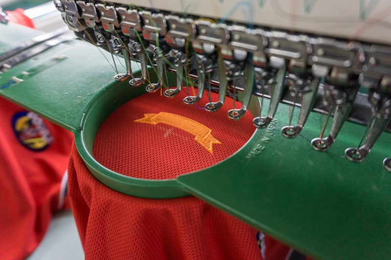 An embroidery machine is used to sew a design onto a shirt.